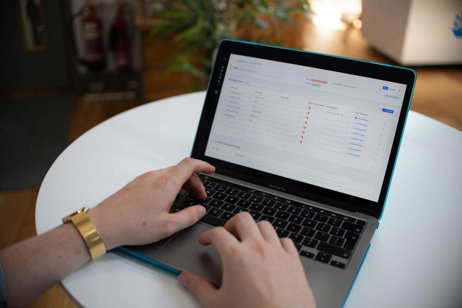 Hands typing on a laptop with a spreadsheet open on screen